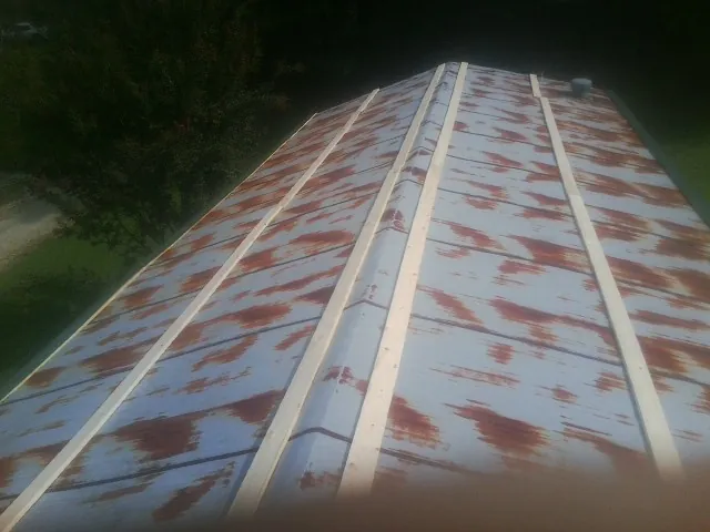 Rusted metal roof panels with new wood purlins before replacement — Storm Damage Roof Repair in Glen Head by Roofing Brothers