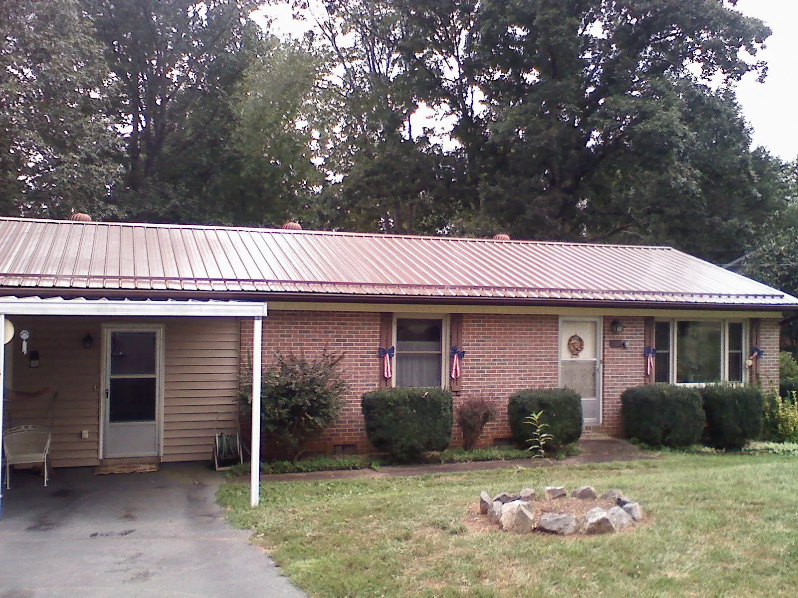 Bronze metal roof and carport on a brick ranch home — Roof Repair work by our crew in Glen Head